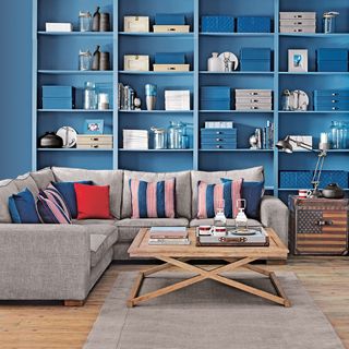 living room with sofa set cups and open blue cupboard