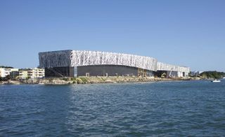 Black granite building covered in matte metal lattice