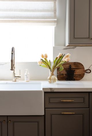 A kitchen with curtain above the sink