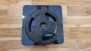 A photo of the Eufy smart scale with a weight on