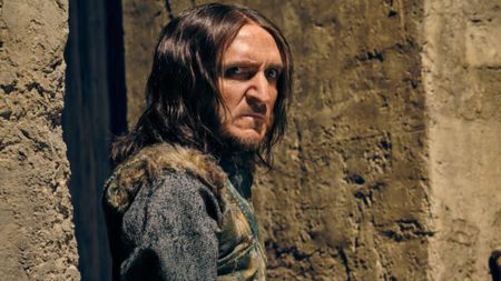 Satyrus leans against a wall