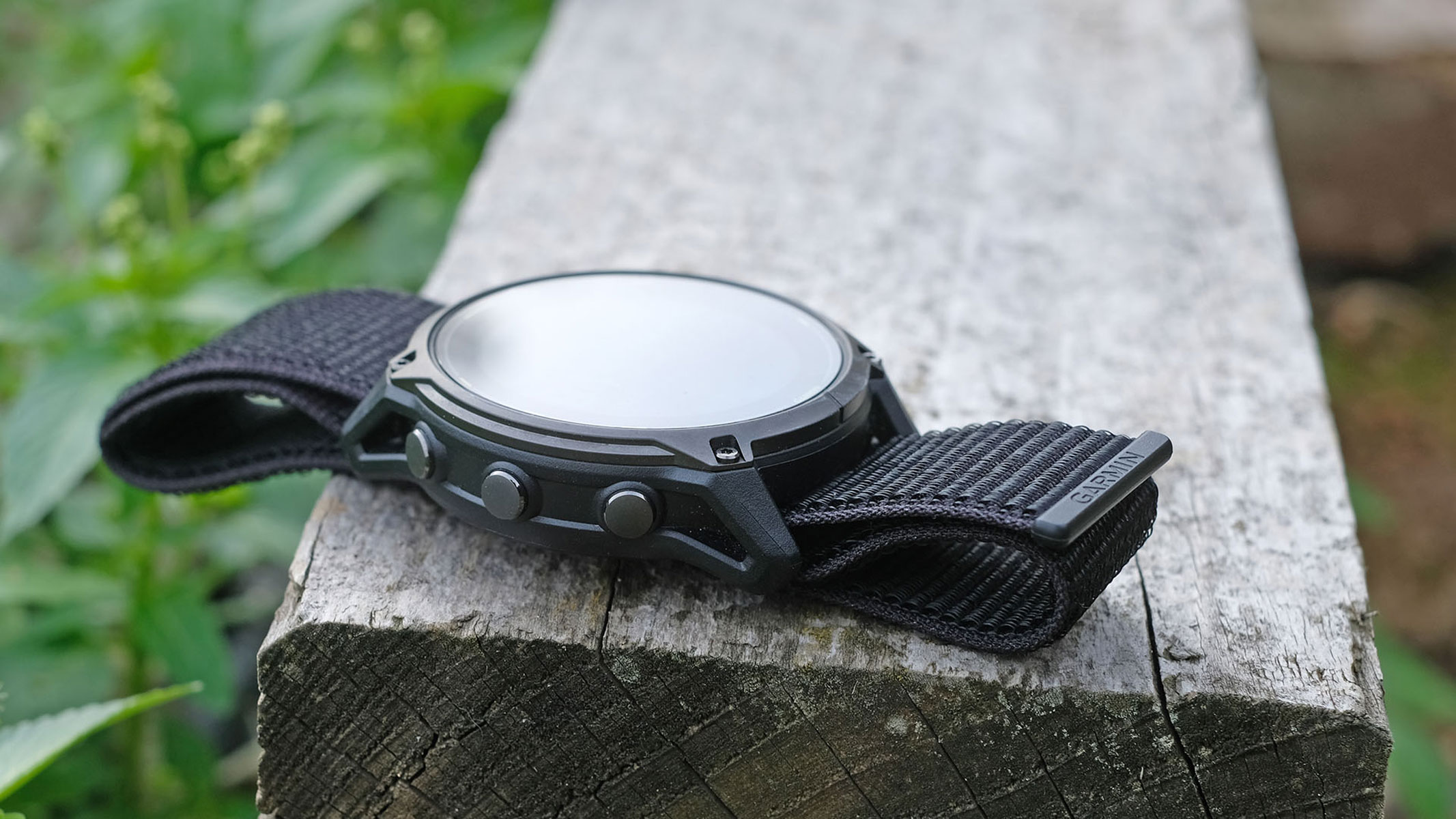 A picture of the Garmin Enduro 3 smartwatch sitting on top of a wooden plank