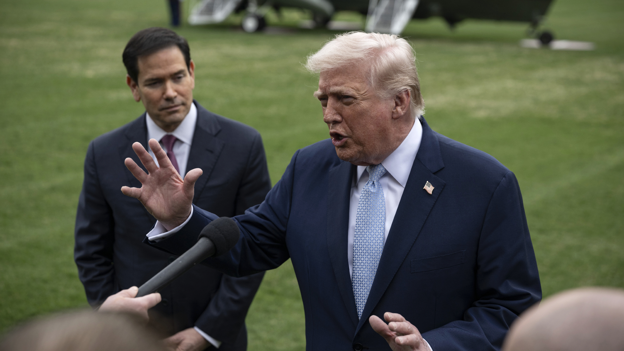 President Donald Trump talks to reporters about Iran with Secretary of State Marco Rubio watching