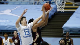 Walker Kessler #13 of the North Carolina Tar Heels battles Scottie Barnes #4 of the Florida State Seminoles.