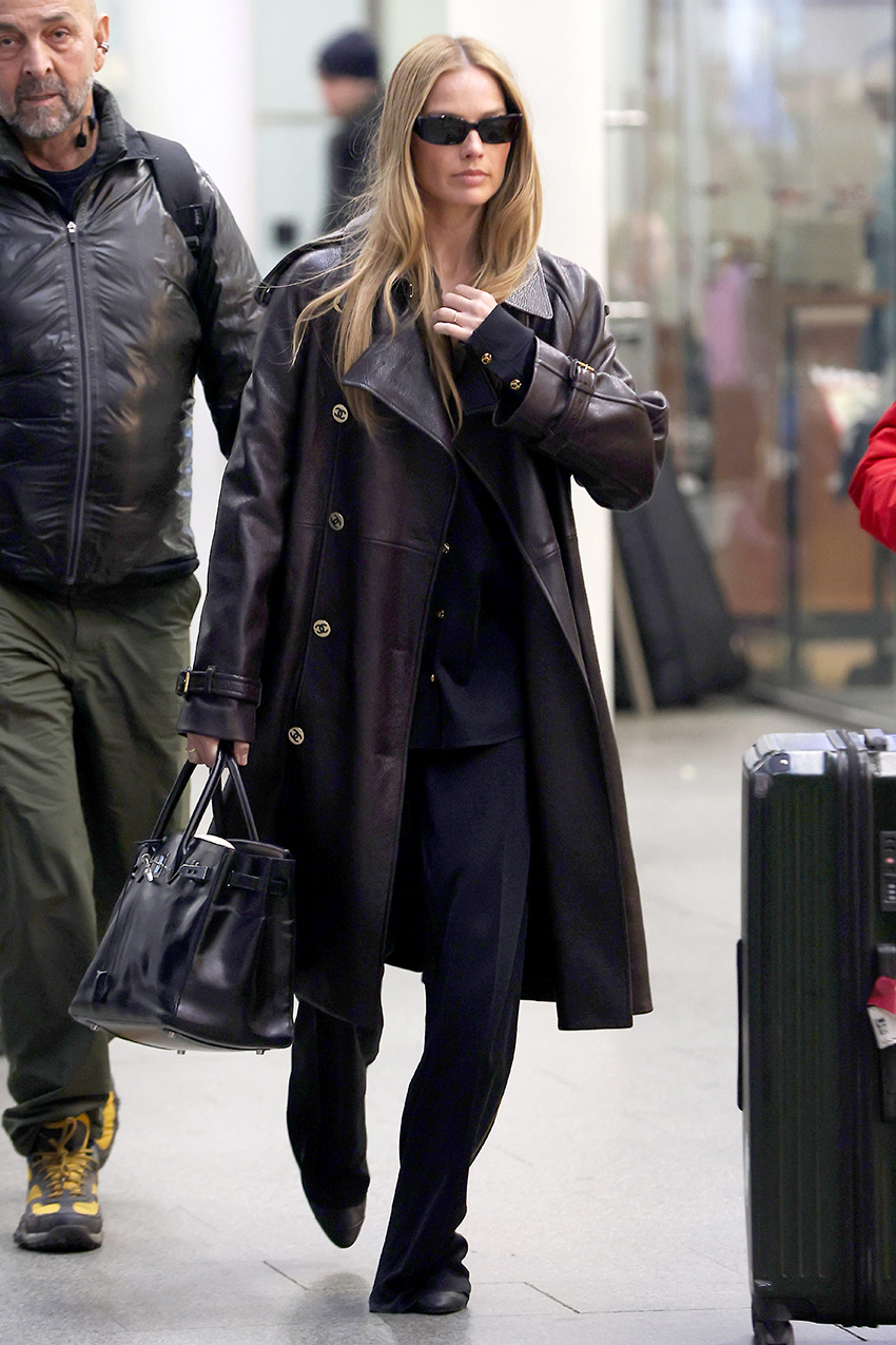 Margot Robbie wearing a Chanel leather trench and track pants at the Eurostar station in Paris