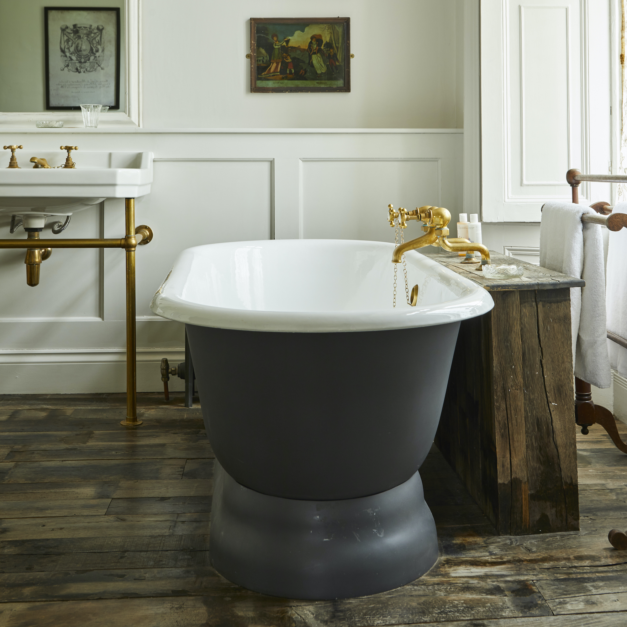 bateau bath in rustic bathroom with brass taps