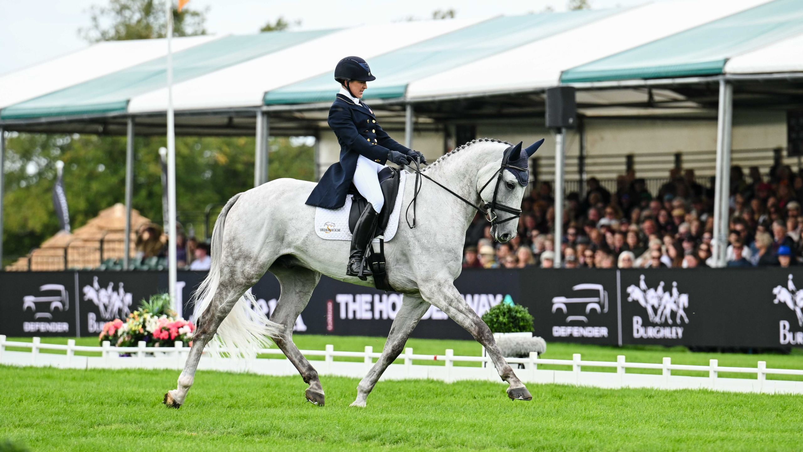 Tiana Coudray riding a medium trot across the diagonal on her grey horse D&rsquo;Artagnan during her dressage test at the Burghley Horse Trials