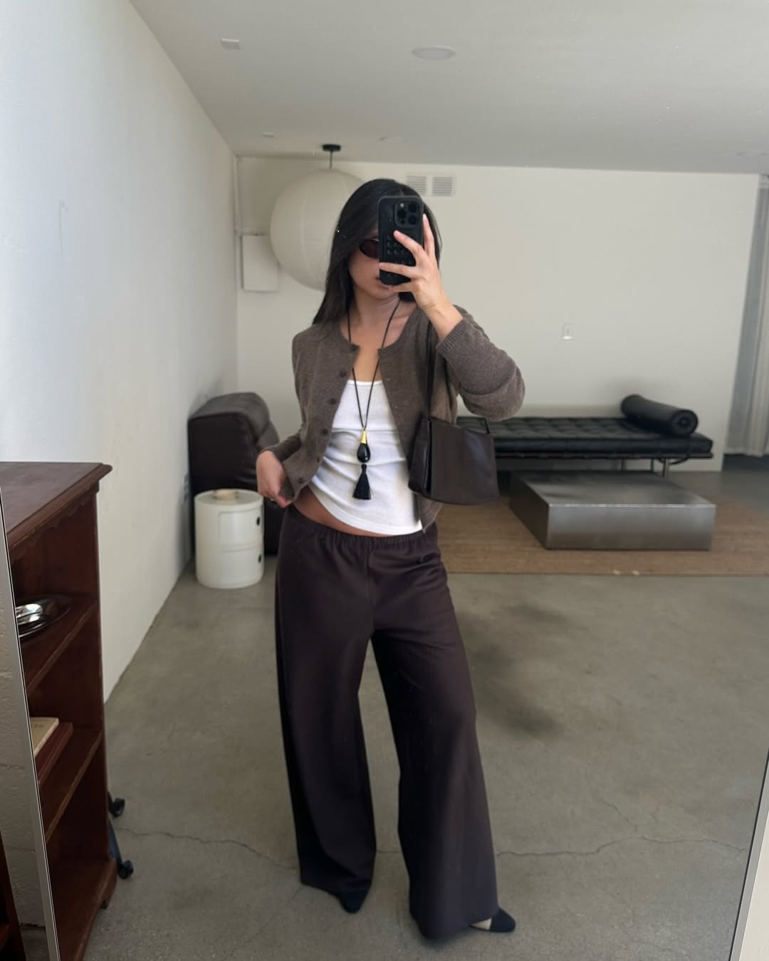 Woman in a cardigan, white tank, and pull-on pants