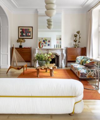 retro living room with orange rug and white sofa