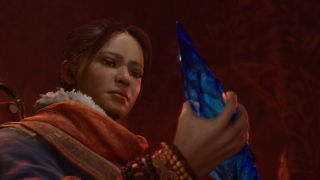 Neyrelle - a determined young woman from Diablo 4 - holds a fiendish soul crystal.
