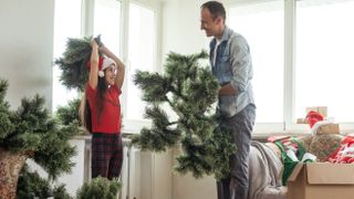 A father and daughter assembling a Christmas tree