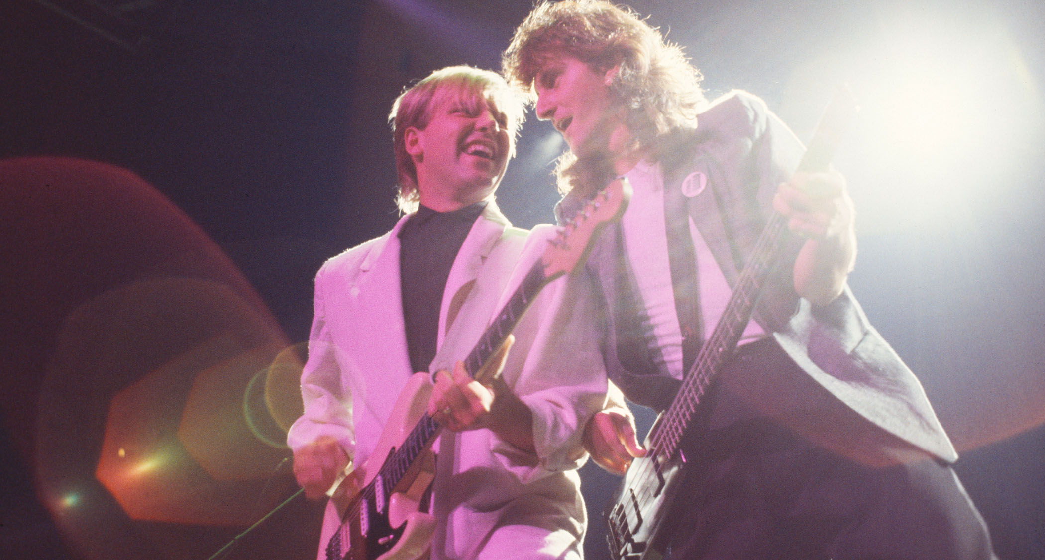 Alex Lifeson and Geddy Lee work that '80s style as they perform live with Rush in 1984.