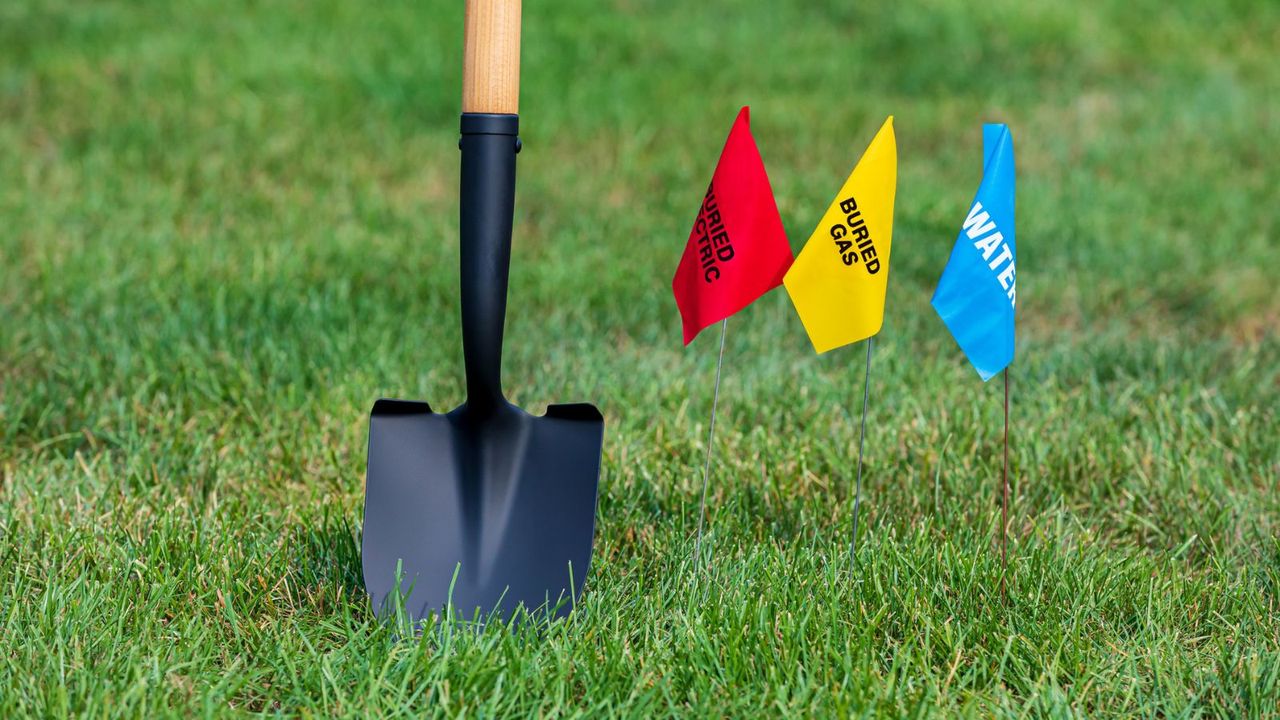 A shovel and utility line warning flags 