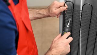 Man fixing fridge condenser