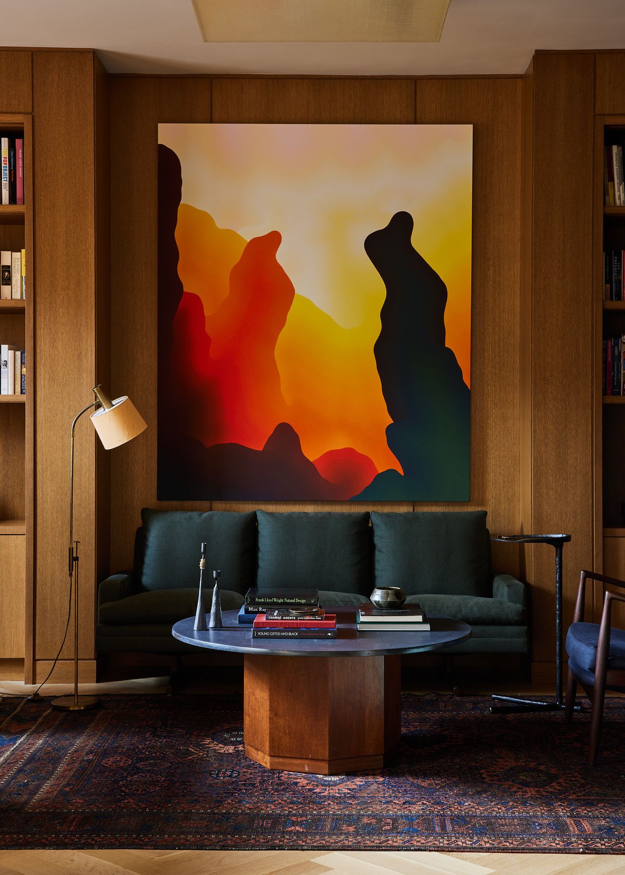 A colorful painting hangs on a wall surrounded by wooden millwork