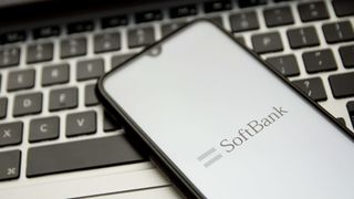 Softbank's logo on a smartphone sitting on a laptop