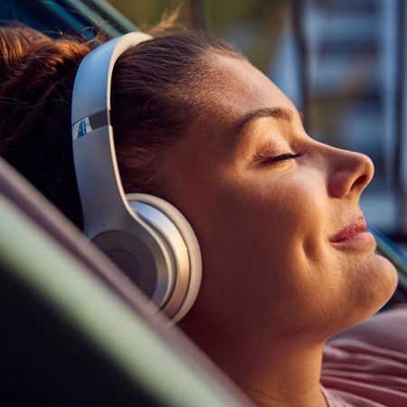 Woman listening to the best self care podcasts in her headphones