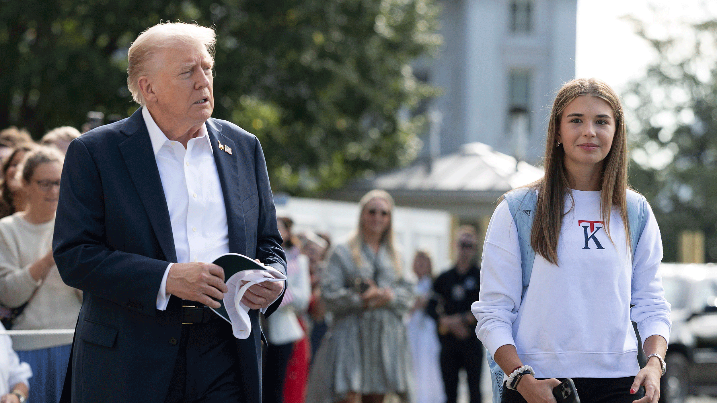 US President Donald Trump (left) walks alongside his granddaughter Kai
