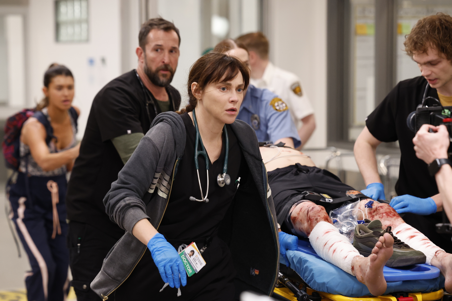 Noah Wyle and Fiona Dourif rushing with a patient with injured legs in the pitt season 2