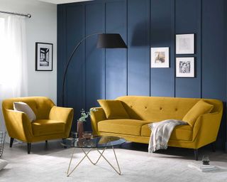 mustard sofa suite in a living room with blue walls and cream rug