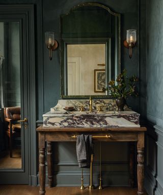 green bathroom with freestanding washstand in wood with marble basin