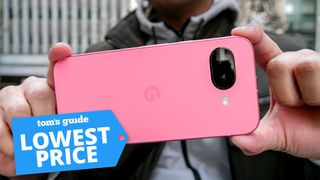 Google Pixel 9a held in the hand with lowest badge nearby.