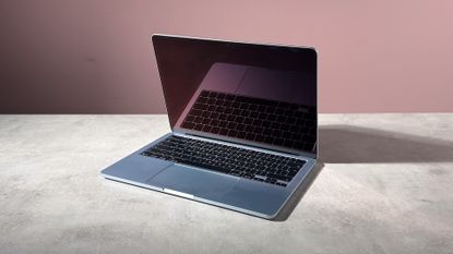 The MacBook Air M5 folded slightly closed, showing a reflection of the keyboard in the screen.