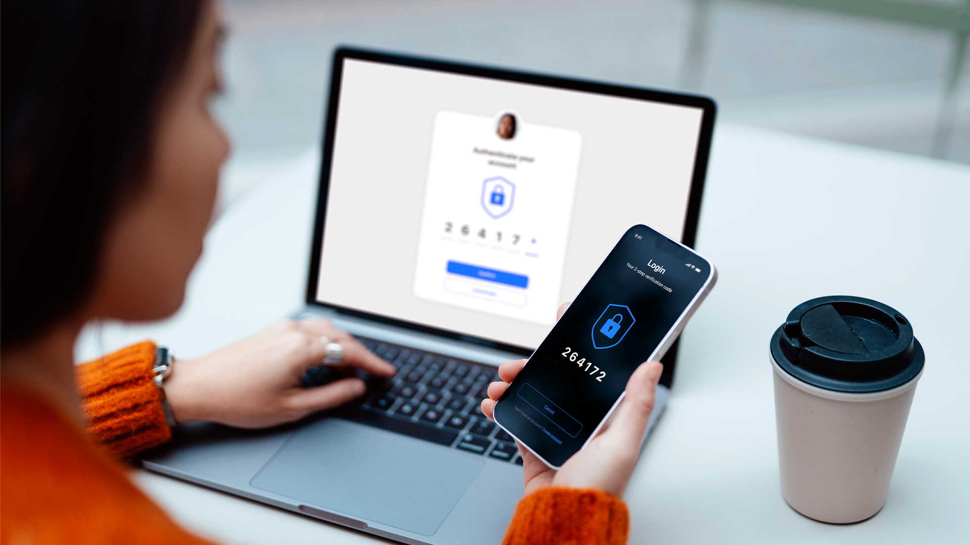 A woman uses two-factor authentication on her phone and her laptop