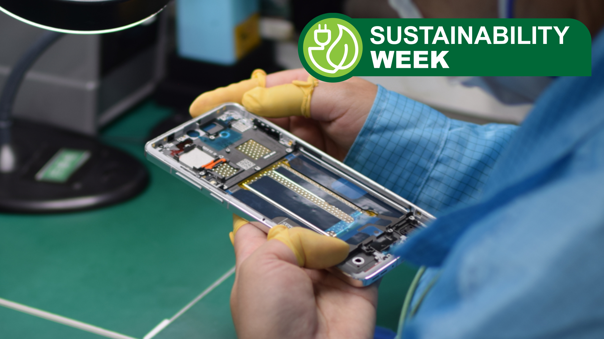 A production line worker handling a partially-built smartphone in their hand