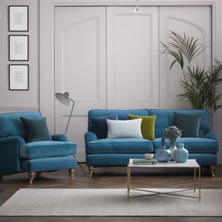 Grey living room with teal velvet sofa and matching armchair