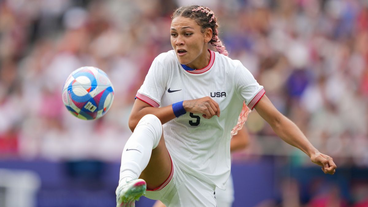 Trinity Rodman, of Team USA, all in white, controls the ball during a soccer match at the 2024 Paris Olympic Games.