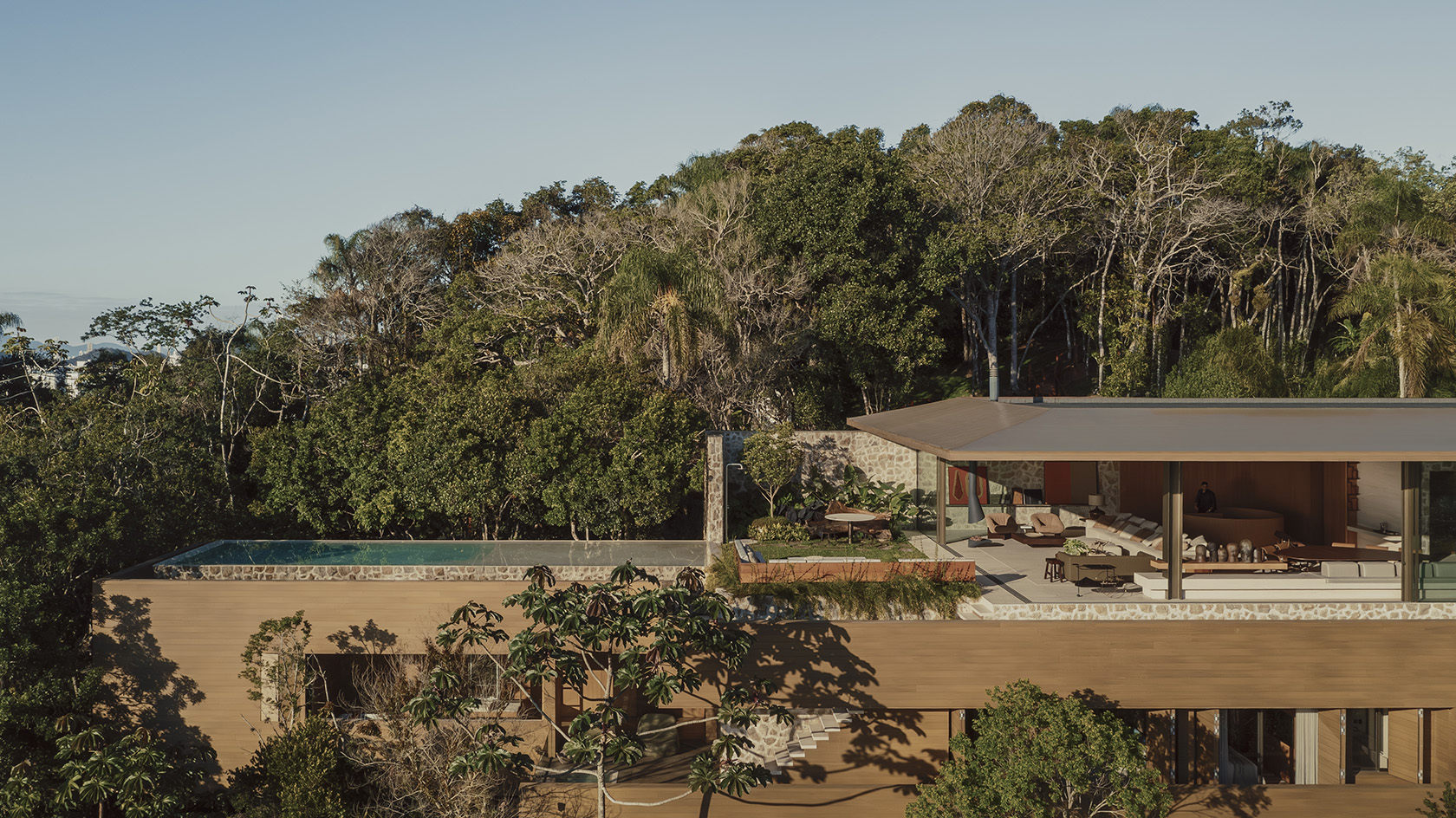 Bravissima House by Arthur Casas, a brazilian house nestled among the forest canopy and rising above the foliage to long views from large windows and ample terraces