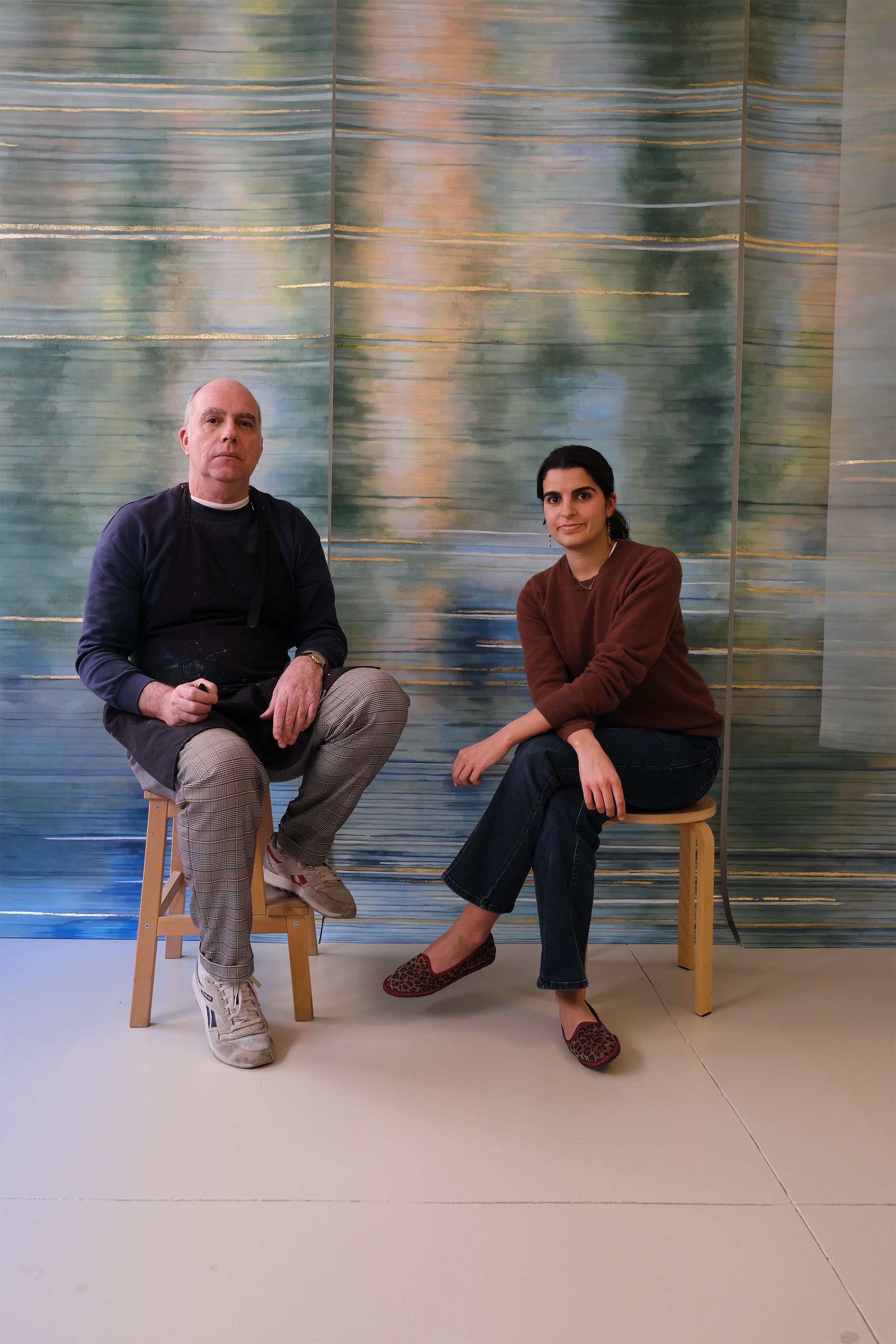 Close-ups of artisanal works in textile and polished stone, and a portrait of two artisans, a man and a woman, sitting in front of a gradient fabric panel in tints of green, blue, orange, and white.