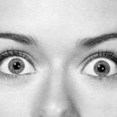 Extreme closeup of a woman's eyes, wide with shock.