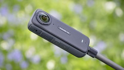 Insta360 X4 360 degree camera outdoors with vibrant grassy background