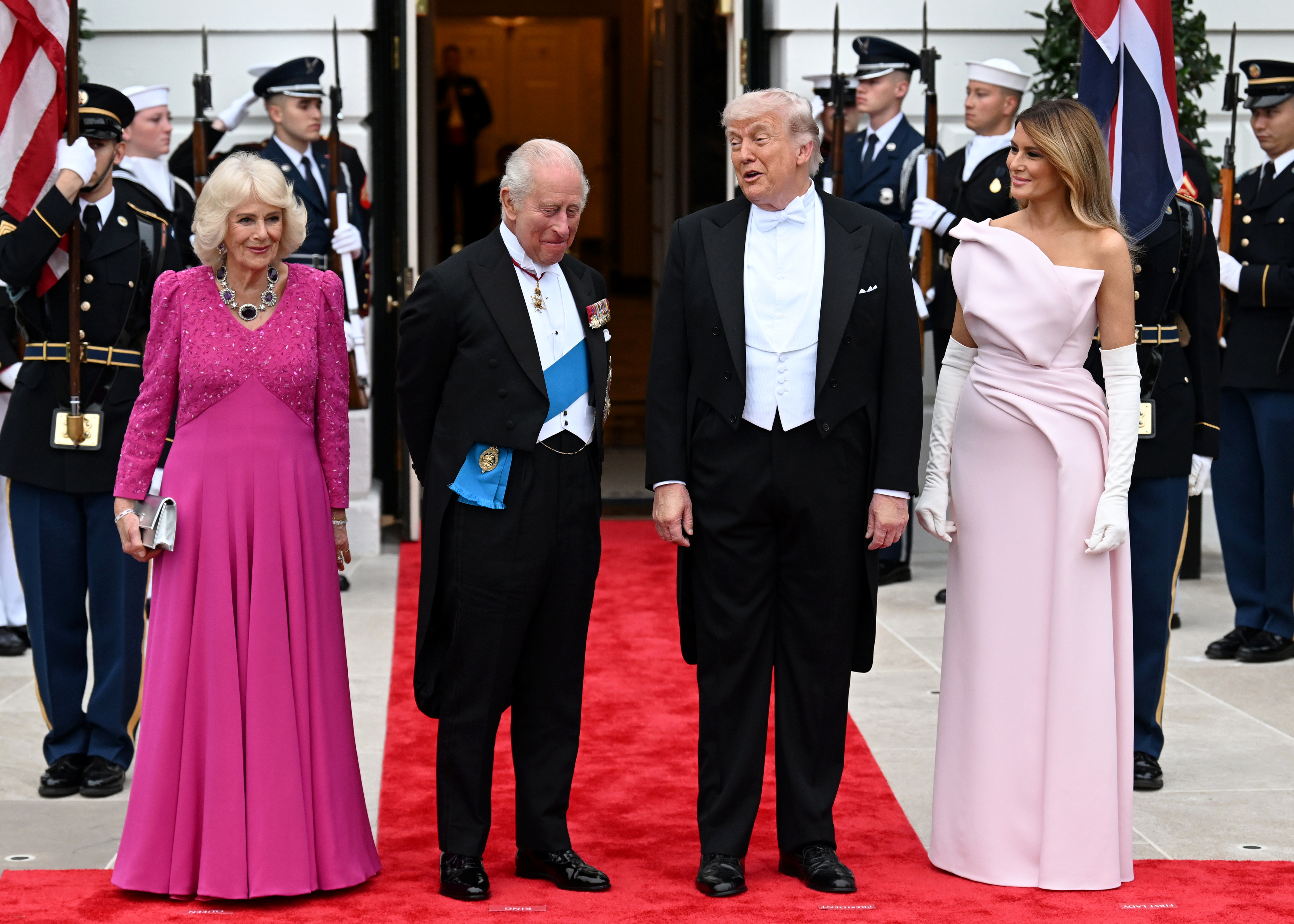 Queen Camilla wearing a pink gown standing with King Charles, Donald and Melania Trump