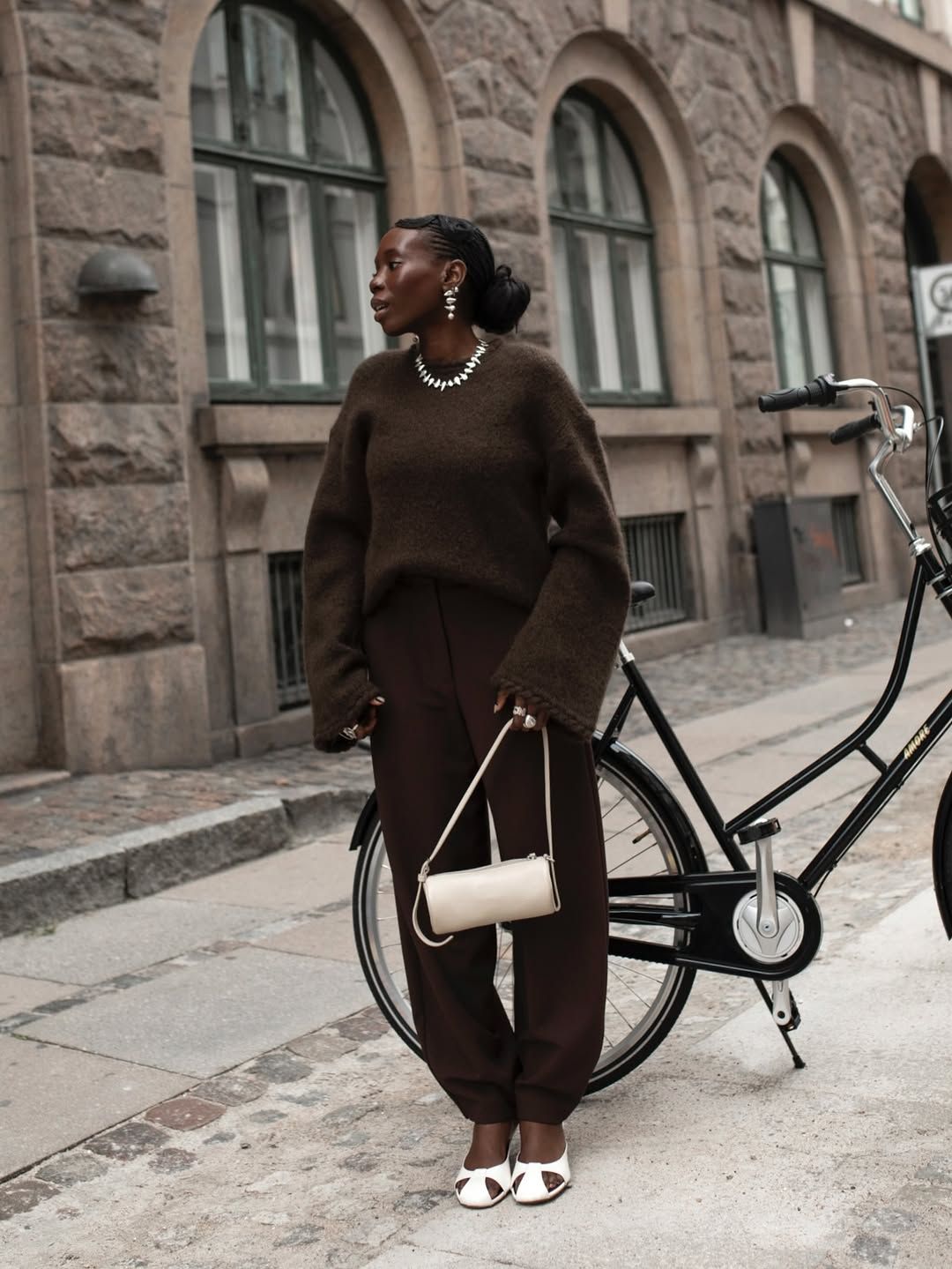 @daniellejinadu wears a pair of brown barrel leg trousers with a brown jumper