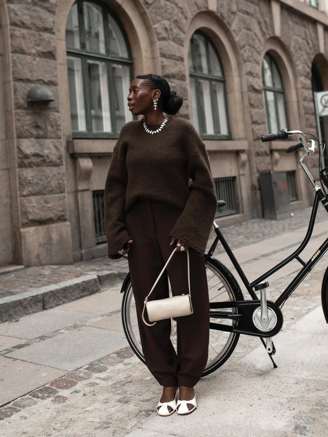 @daniellejinadu wears a pair of brown barrel leg trousers with a brown jumper