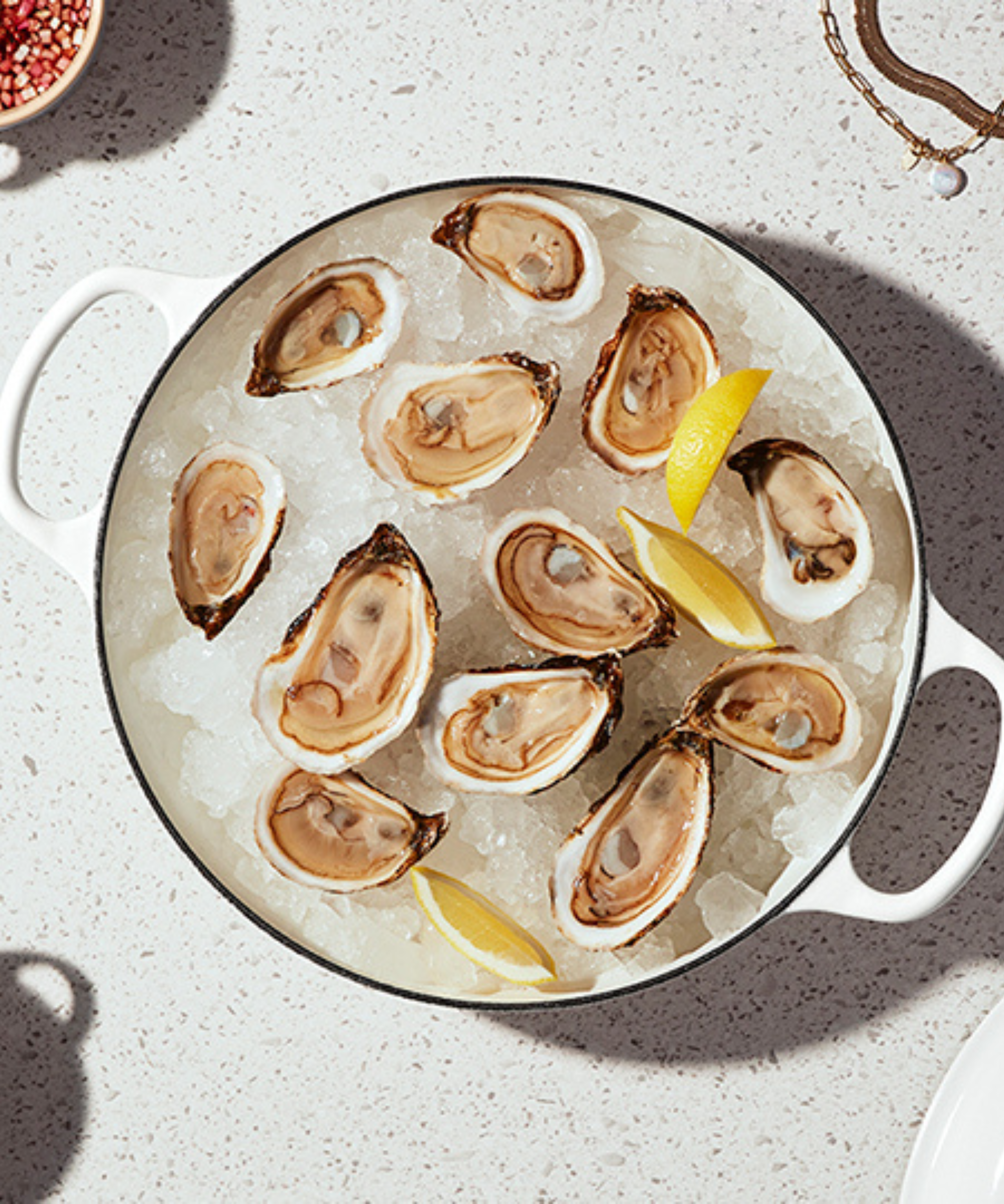 Le Creuset White Cast Iron Cocotte holding crushed ice and fresh oysters