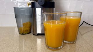 Two glasses of orange juice made in the AMZCHEF juicer