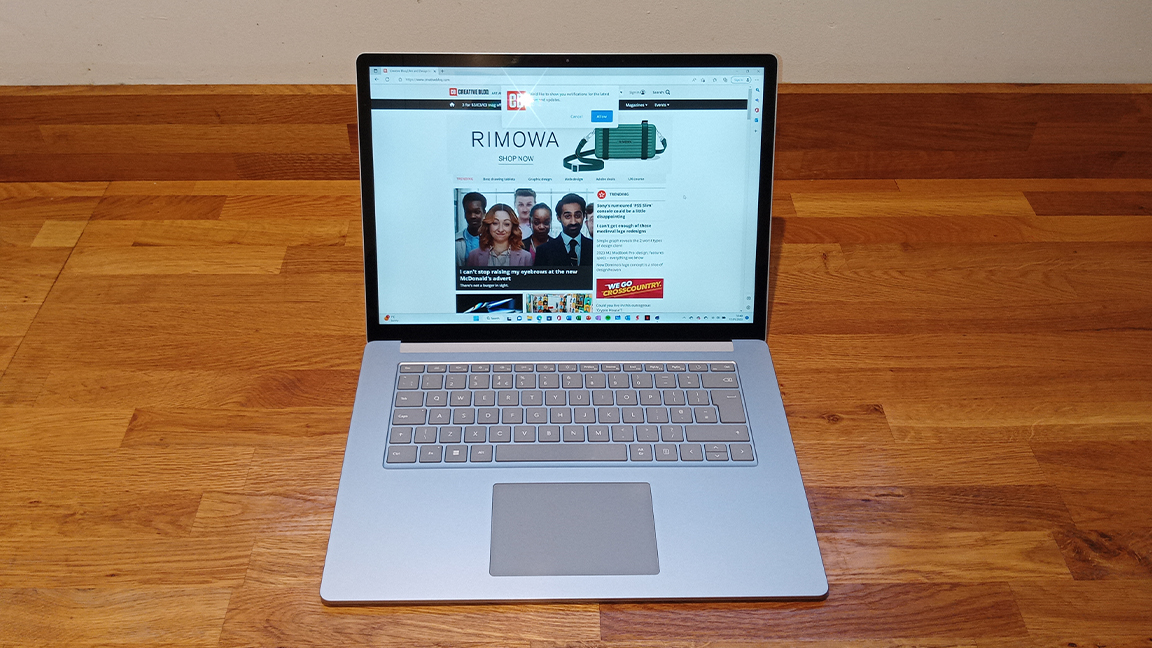 Surface Laptop 5 review; a silver chrome laptop on a wooden desk