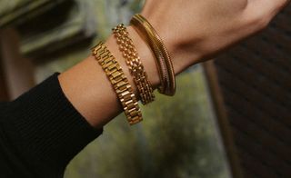 Gold bracelets on model's arm