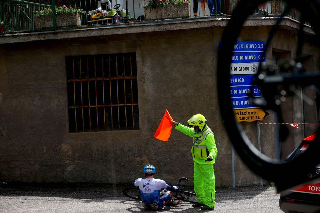 LAVARONE, ITALY - MAY 25: Alex Dowsett of United Kingdom and Team Israel - Premier Tech crashes and an operator protects the riderduring the 105th Giro d'Italia 2022, Stage 17 a 168 km stage from Ponte di Legno to Lavarone 1161m / #Giro / #WorldTour / on May 25, 2022 in Lavarone, Italy. (Photo by Michael Steele/Getty Images)