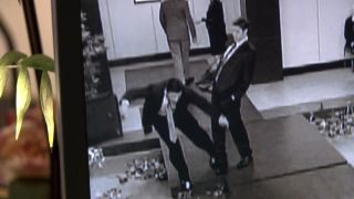 Security camera image of Jim leaning away from Michael in The Office