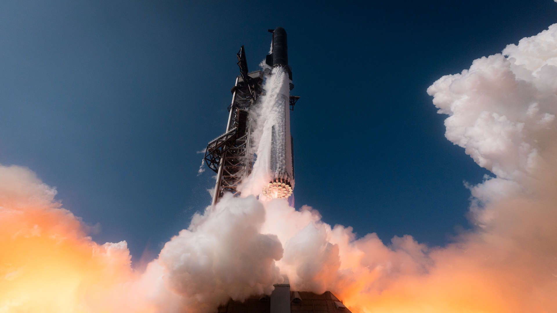 a large silver rocket launches above a plume of fire
