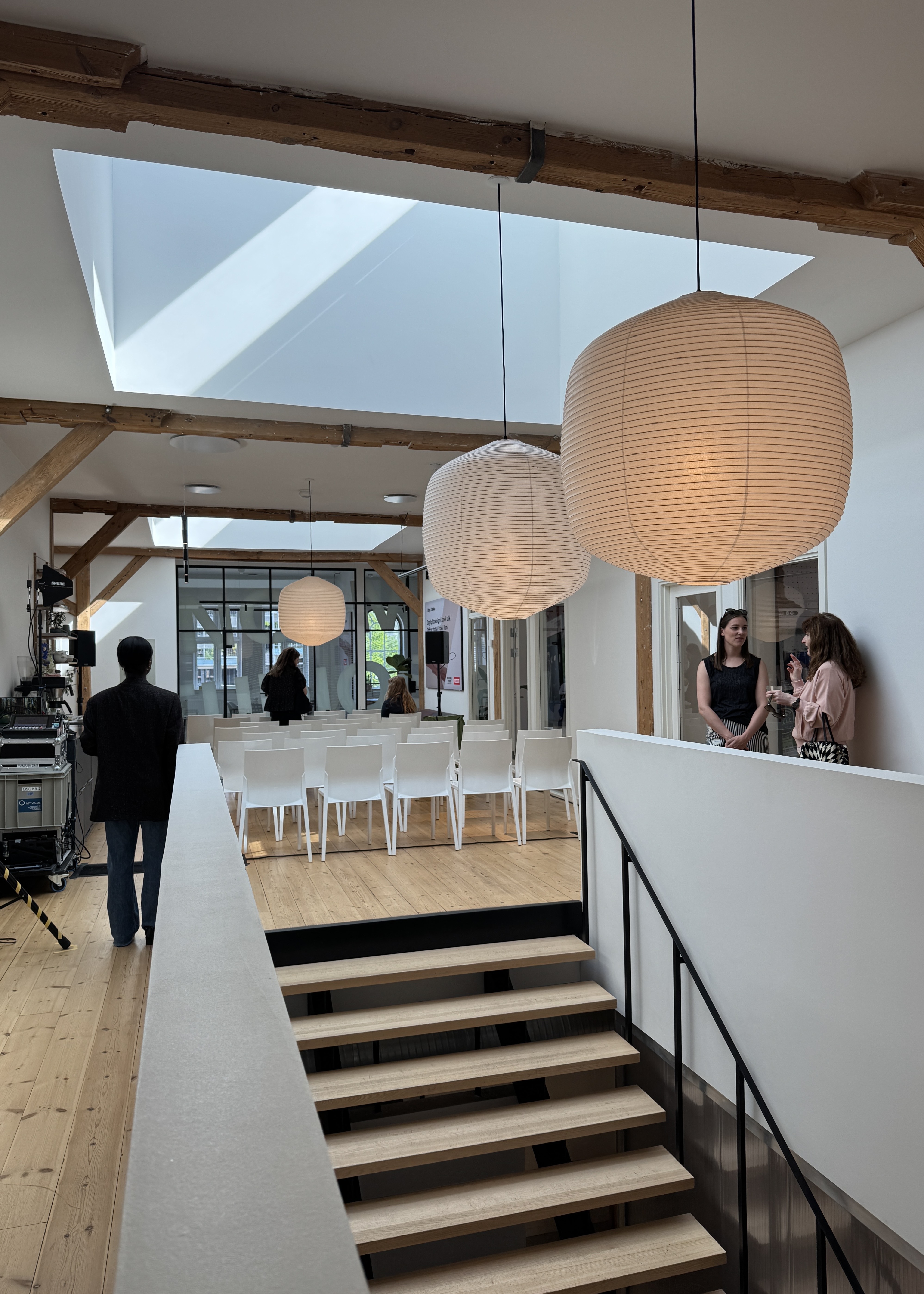 office space with velux roof windows and paper lantern lights hanging over staircase