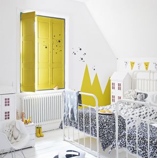 White bedroom with paint wall art, twin beds and yellow shutters