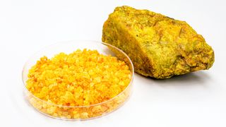 Uranium nitrate called uranyl, with uranium ore, radioactive material on isolated white background_RHJ via Getty Images