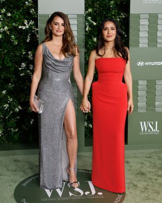 A photo of Salma Hayek and Penélope Cruz holding hands on the red carpet at WSJ. Magazine’s 14th Annual Innovator Awards