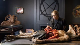 Sculptor Sarah Hardy poses with edible demon corpse